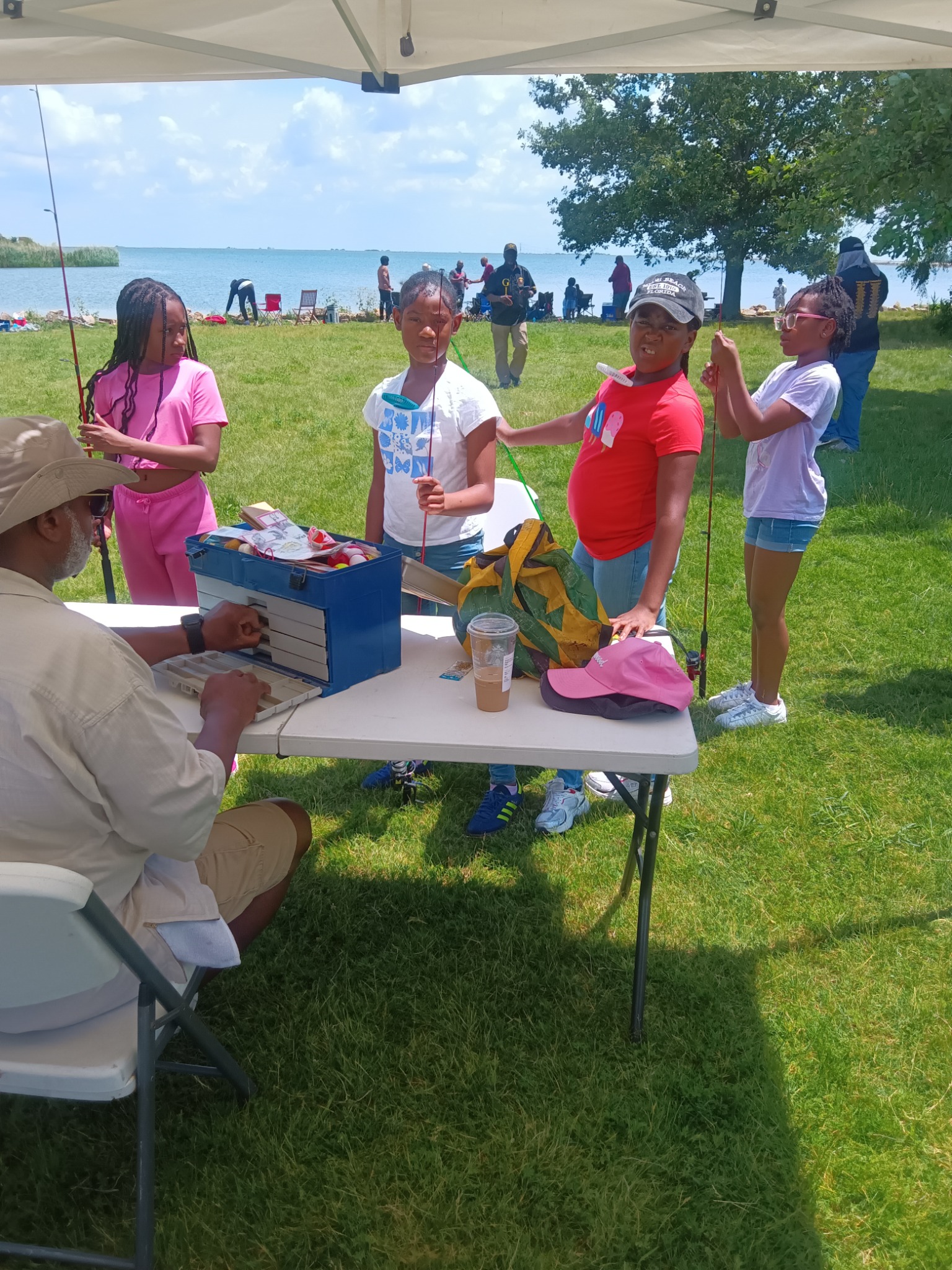 Young people learning fishing skills with adult volunteers